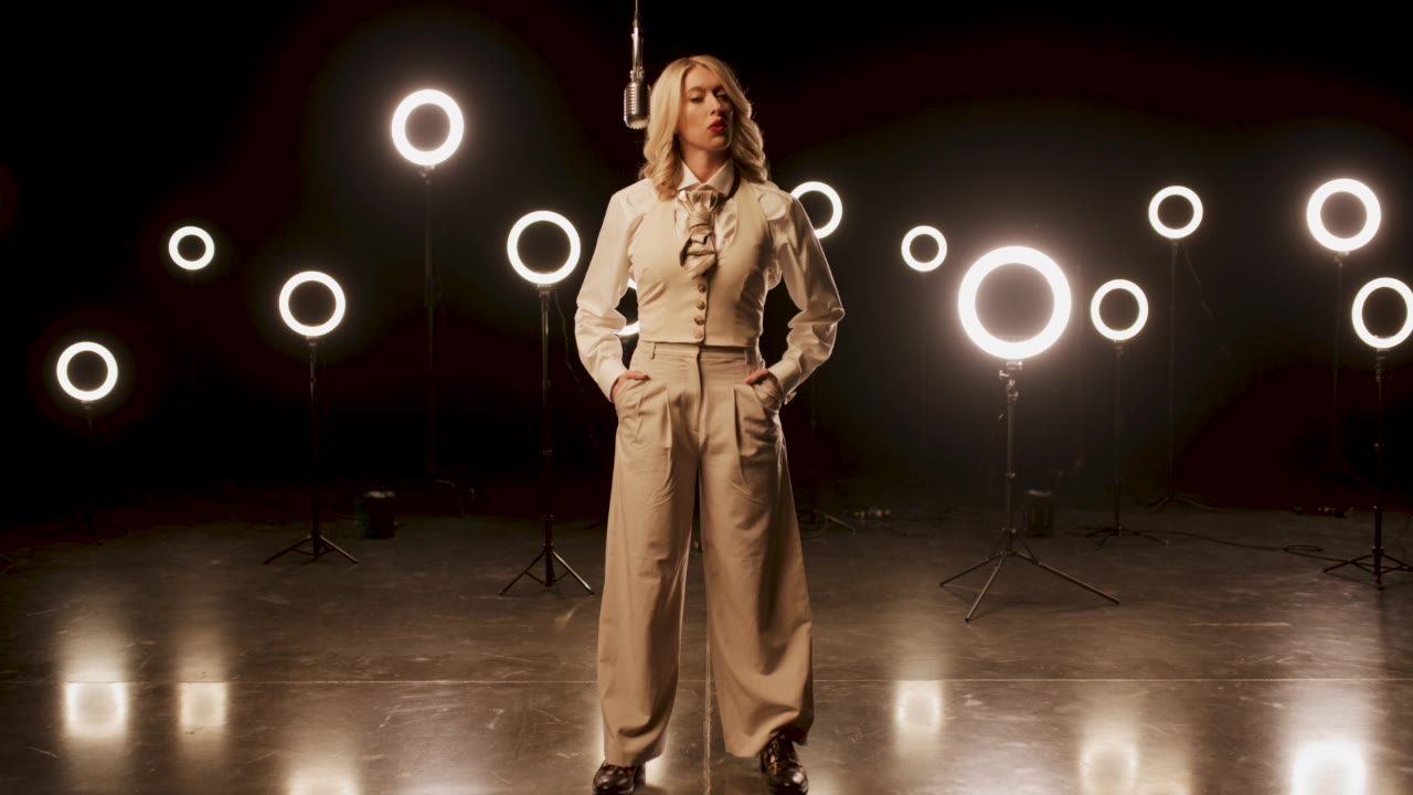Creator on a stage ringed with lights, from the Curated launch film
